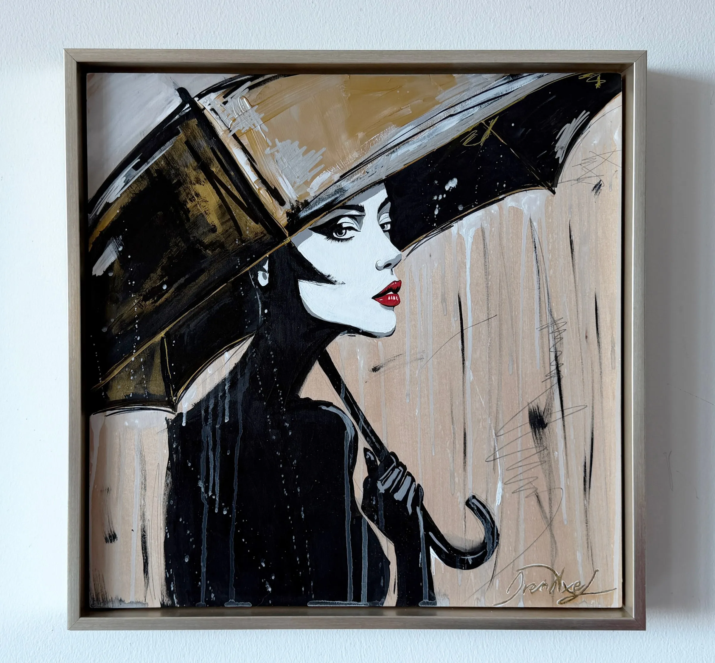 Framed in a gold-toned floater frame: a woman with red lips beneath a black umbrella, in black, white and gold